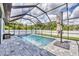 Refreshing screened-in pool features a relaxing escape with lush greenery and clear blue water at 1269 N Lavina St, North Port, FL 34286