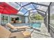 Lounge by the screened-in pool, adjacent to outdoor dining and kitchen, perfect for entertainment at 1269 N Lavina St, North Port, FL 34286