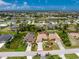Wide aerial shot showcasing a single-Gathering home with spacious driveway, lush greenery, and beautiful landscaping at 127 Jennifer Dr, Rotonda West, FL 33947