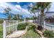 Spacious backyard featuring a white picket fence, manicured lawn, and access to the enclosed pool area, offering a private oasis at 127 Jennifer Dr, Rotonda West, FL 33947