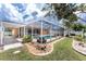 Lush backyard showcases a well-maintained lawn, rock garden, access to the screened pool, and seamless indoor-outdoor living at 127 Jennifer Dr, Rotonda West, FL 33947