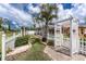 Expansive backyard with a white picket fence, lush lawn, white stone accents, and view of the screened-in pool for outdoor enjoyment at 127 Jennifer Dr, Rotonda West, FL 33947