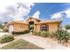 Charming single-story home featuring well-manicured landscaping, a tiled walkway, and a screened entryway at 127 Jennifer Dr, Rotonda West, FL 33947