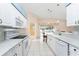 Well-lit kitchen boasting white cabinetry, modern appliances, and a breakfast bar overlooking the pool at 127 Jennifer Dr, Rotonda West, FL 33947