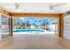 Screened-in patio with ceiling fans overlooks a sparkling pool and landscaped backyard at 127 Jennifer Dr, Rotonda West, FL 33947