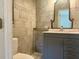 Modern bathroom featuring tiled walls, vanity with storage, and decorative mirror at 133 Paddington Rd, Venice, FL 34293
