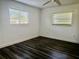 Bedroom featuring sleek dark wood flooring, white walls, and natural light through large windows at 133 Paddington Rd, Venice, FL 34293