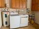 Laundry room with washer, dryer, and water heater with overhead storage at 133 Paddington Rd, Venice, FL 34293