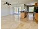 Open-concept living area with a travertine-style flooring and access to kitchen at 133 Paddington Rd, Venice, FL 34293