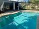 A refreshing pool in an enclosed lanai featuring a clean, turquoise swimming pool and outdoor lounging area at 133 Paddington Rd, Venice, FL 34293