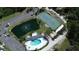 Aerial view of community amenities featuring a pool, tennis court, pond, and ample parking at 1401 S Mccall Rd # 101, Englewood, FL 34223
