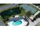Aerial view featuring a pool, tennis court, pond, and shuffleboard at this lovely community at 1401 S Mccall Rd # 101, Englewood, FL 34223