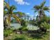 Community tennis court surrounded by lush tropical landscaping and mature palm trees at 1401 S Mccall Rd # 101, Englewood, FL 34223