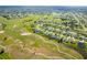 Aerial view features a waterfront neighborhood next to a golf course with lush landscaping and amenities at 15 Bunker Pl, Rotonda West, FL 33947