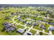 Aerial view showcasing a waterfront home, surrounded by a golf course, lush landscaping and neighborhood at 15 Bunker Pl, Rotonda West, FL 33947