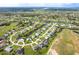 Aerial view of a neighborhood surrounded by golf course and canals with the home highlighted at 15 Bunker Pl, Rotonda West, FL 33947