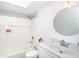 A clean and bright bathroom with a shower and tub combo and a round decorative mirror at 15 Bunker Pl, Rotonda West, FL 33947