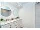 This bathroom boasts dual sinks with marble countertops and round decorative mirrors at 15 Bunker Pl, Rotonda West, FL 33947