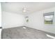 Bedroom features large windows with backyard views, gray floors, and neutral decor at 15 Bunker Pl, Rotonda West, FL 33947