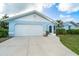 Exterior of a one-story home with a two car garage, featuring a well maintained lawn at 15 Bunker Pl, Rotonda West, FL 33947
