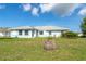 Charming home with a well-manicured lawn and an inviting exterior featuring a blue color palette at 15 Bunker Pl, Rotonda West, FL 33947
