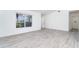 Spacious living room with new gray flooring, natural lighting, and a view to the entry at 15 Bunker Pl, Rotonda West, FL 33947
