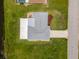 A top-down aerial view of a home, revealing the roof, lawn and driveway at 15 Oakland Hills Pl, Rotonda West, FL 33947