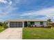 Charming single-story home featuring a well-maintained lawn and an attached garage at 15 Oakland Hills Pl, Rotonda West, FL 33947