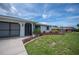Well-manicured front yard featuring colorful landscaping and a driveway leading to a garage at 15 Oakland Hills Pl, Rotonda West, FL 33947