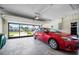 Spacious garage with a red car, offering ample parking and storage space with an automatic door opener at 15 Oakland Hills Pl, Rotonda West, FL 33947