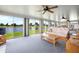Bright living room featuring large windows with a view of a serene lake and comfortable seating at 15 Oakland Hills Pl, Rotonda West, FL 33947