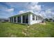 The rear exterior of the property featuring a Florida room with large windows at 15 Oakland Hills Pl, Rotonda West, FL 33947