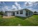 The rear exterior of the property with a large Florida room and a well-maintained lawn at 15 Oakland Hills Pl, Rotonda West, FL 33947
