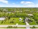 Gorgeous landscaped yard with a charming residence nestled among lush greenery and mature palm trees at 15521 Lakeland Cir, Port Charlotte, FL 33981