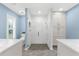 Modern bathroom featuring a tiled walk-in shower, white cabinets and blue accent walls at 15521 Lakeland Cir, Port Charlotte, FL 33981