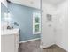 Stylish bathroom featuring a walk-in shower, blue accent wall and a modern vanity and mirror at 15521 Lakeland Cir, Port Charlotte, FL 33981