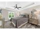 Comfortable bedroom featuring a stylish bed, ceiling fan, window and dressers with accent lighting at 15521 Lakeland Cir, Port Charlotte, FL 33981