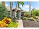 Inviting home entrance with tropical landscaping and a well-maintained walkway at 15521 Lakeland Cir, Port Charlotte, FL 33981