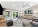 Inviting living room featuring stylish seating, a decorative rug, a ceiling fan, and an outdoor view at 15521 Lakeland Cir, Port Charlotte, FL 33981