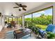 Enclosed sunroom with tile floors, ceiling fans, and a view of the lush backyard at 15521 Lakeland Cir, Port Charlotte, FL 33981