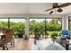 Enclosed sunroom with tile floors, ceiling fan, and a view of the lush backyard at 15521 Lakeland Cir, Port Charlotte, FL 33981