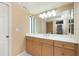 Bathroom featuring a large mirror, white countertop, wood cabinets, and natural light at 1640 Atares # 23, Punta Gorda, FL 33950