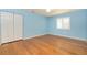 Light-filled bedroom features light blue walls, wood floors, and a double-door closet at 1640 Atares # 23, Punta Gorda, FL 33950