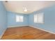 Bright bedroom with light blue walls, wood floors, and white plantation shutters on the windows at 1640 Atares # 23, Punta Gorda, FL 33950