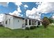 Exterior of a bright white home with a well-manicured lawn and mature landscaping at 1640 Atares # 23, Punta Gorda, FL 33950