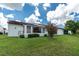 Exterior of a bright white home with a well-manicured lawn and mature landscaping at 1640 Atares # 23, Punta Gorda, FL 33950