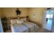 Comfortable bedroom with light colors, wicker headboard and furnishings, leading to the bathroom at 1760 Gulf Blvd # 511, Englewood, FL 34223