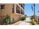 Oceanside condominium exterior with landscaped walkway and peek of beach at 1760 Gulf Blvd # 511, Englewood, FL 34223