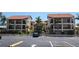 Condominium complex with a two-story building, parking, and surrounding palm trees at 1760 Gulf Blvd # 511, Englewood, FL 34223