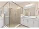Modern bathroom featuring a glass-enclosed shower, dual vanities, and neutral tile work at 17605 Boracay Ct # 201, Venice, FL 34293